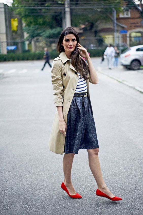 woman in  stylish trench coat with a nice and cute skirt and red ballet flats