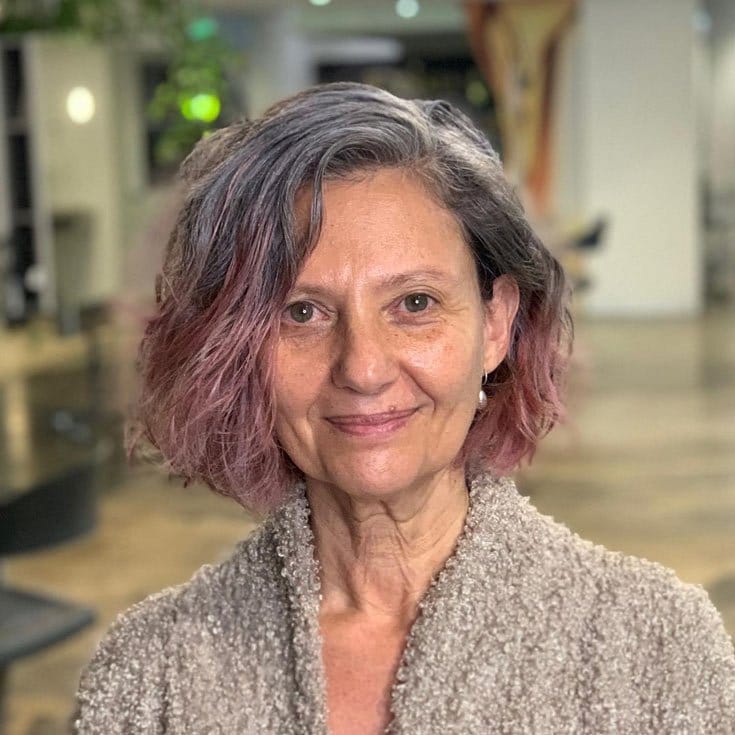 Older woman with curly bob and color tip