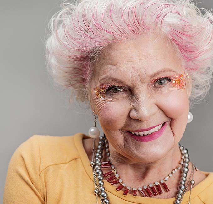 Woman over 60 with dusty pink unicorn hair