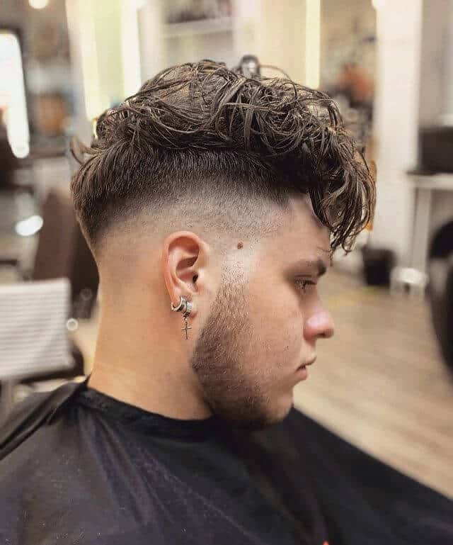 Men's round face hairstyle with curly bangs