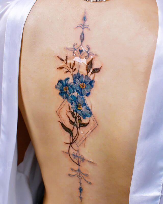 blue flower tattoo on back